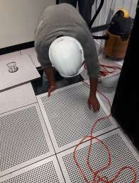 Técnico realizando mantenimiento bajo piso técnico